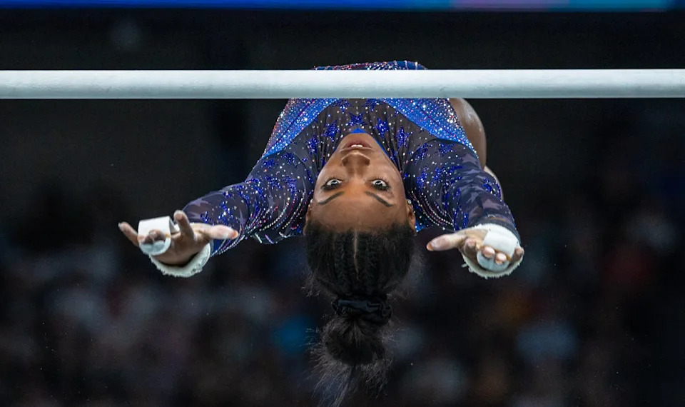 Simone Biles, the champion gymnast floats through the air with her eyes firmly riveted on a bar.