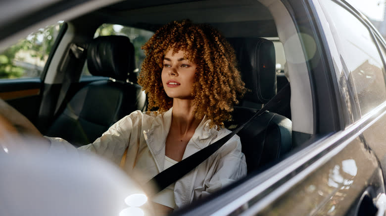 A woman drives thoughtfully