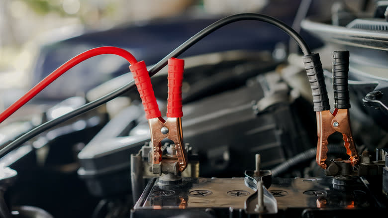 A pair of jumper cables attached to a car battery