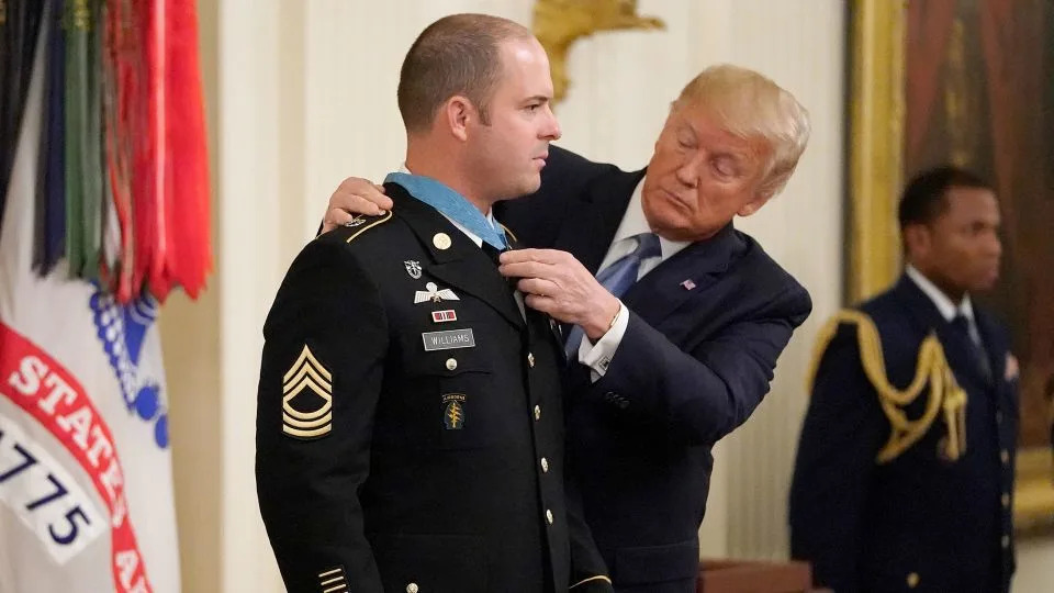 President Donald Trump helps straighten the Medal of Honor after presenting the award to Army Master Sgt. Matthew Williams in 2019. Williams received the nation’s highest military honor for heroic actions while serving in Afghanistan's Shok Valley in 2008. - Win McNamee/Getty Images/File