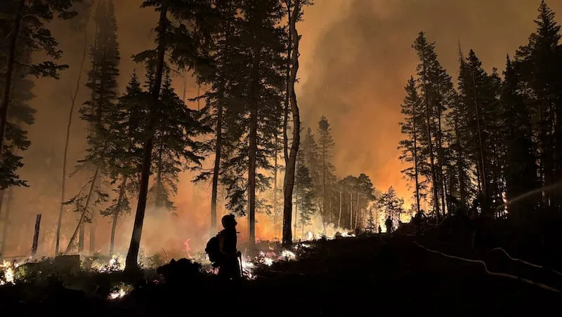 In this photo provided by the Hurricane Valley Fire District, firefighters work to subdue the Monroe Canyon Fire near Monroe, Utah, Thursday, July 24, 2025.