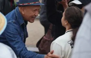 A man greets a young girl during a handshake across the U.S. and Canada border organized by the International Peace Garden, a botanical garden straddling North Dakota and Manitoba. (Photo by Mary Steurer/North Dakota Monitor)