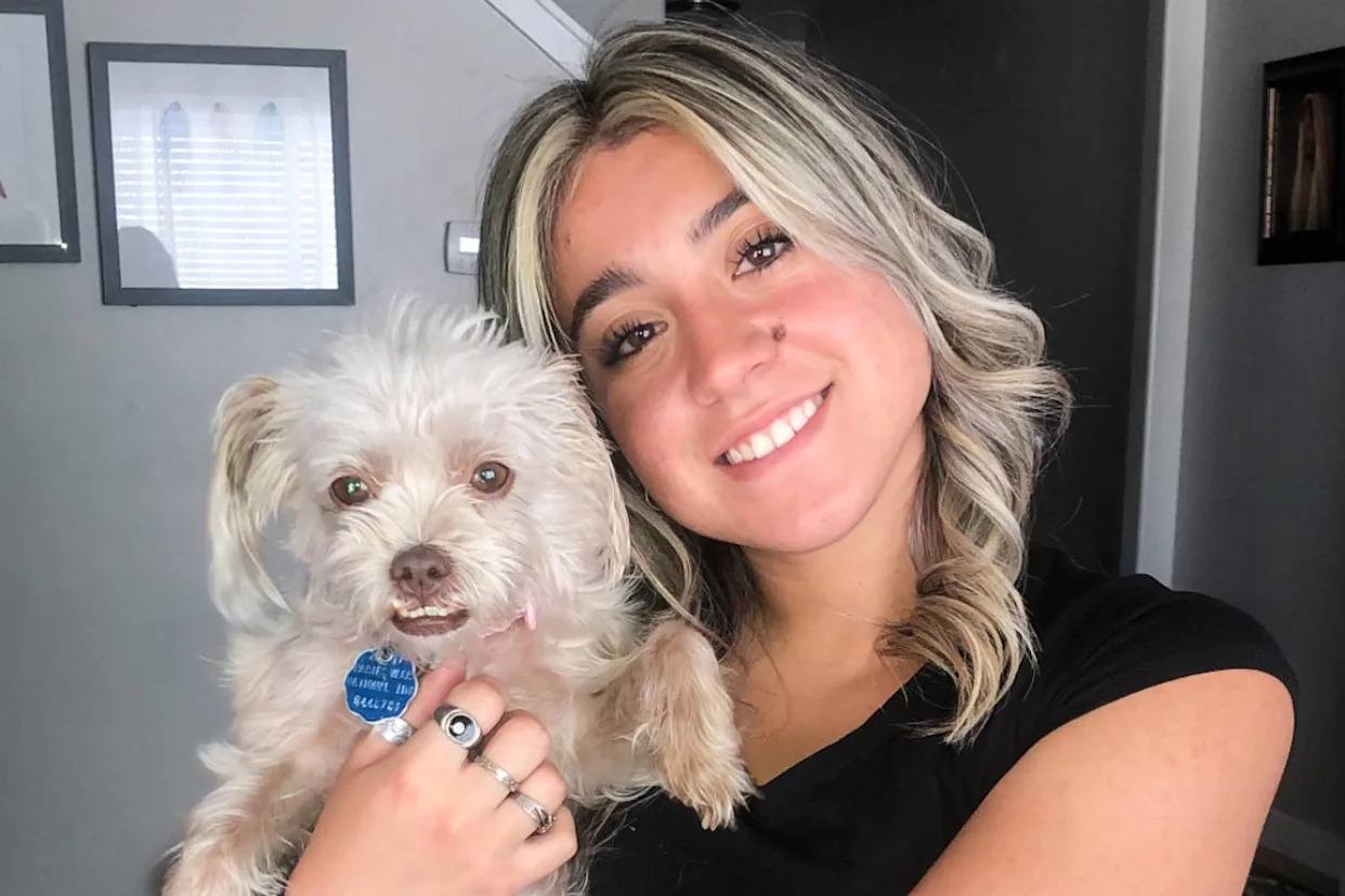 Caroline Dias Goncalves holds a dog and smiles for a portrait (via GoFundMe)