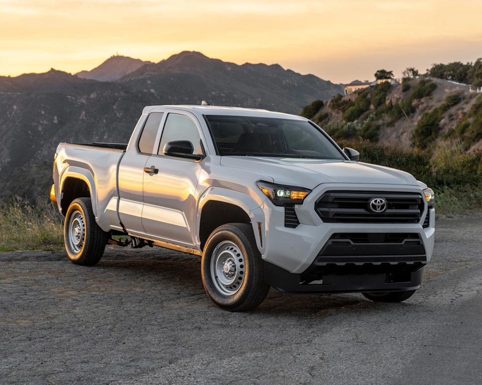 a photo of a white toyota tacoma against a sunset backdrop