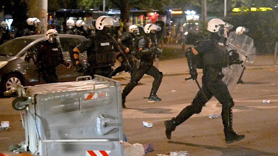 Serbian riot police clash with anti-government protesters in Belgrade on August 13.
