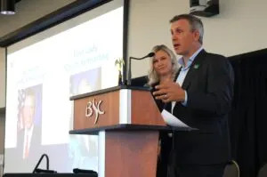  Gov. Kelly Armstrong speaks during the 2025 Global Talent Summit next to first lady Kjersti Armstrong at Bismarck State College on Aug. 14, 2025. (Michael Achterling/North Dakota Monitor)