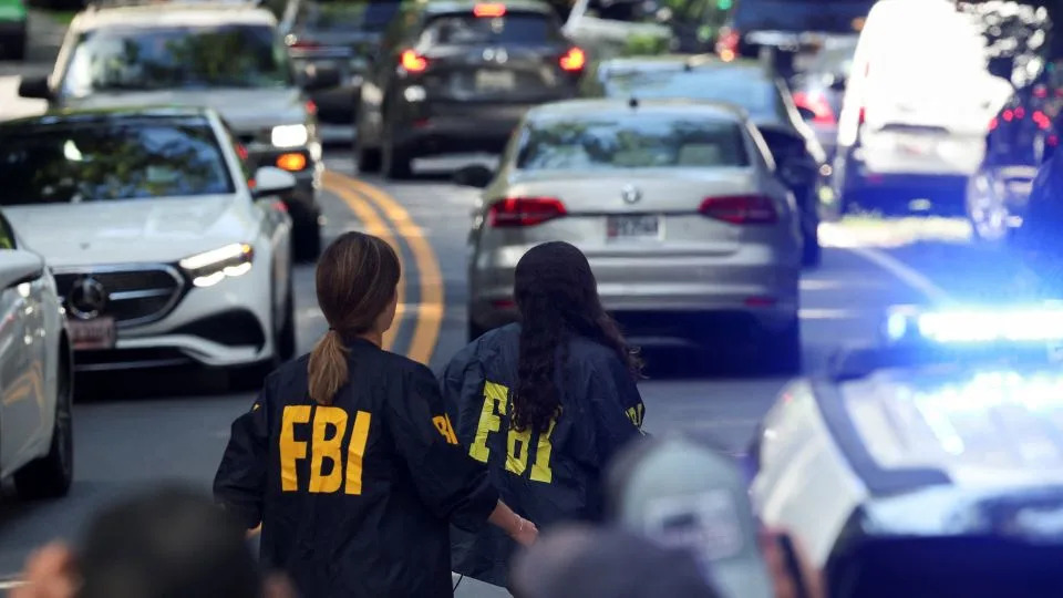 FBI members walk outside the home of the former White House national security adviser John Bolton in Bethesda, Maryland on August 22. - Tasos Katopodis/Reuters