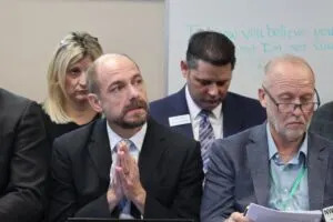Attorney Derrick Braaten, left, and Troy Coons, head of the Northwest Landowners Association, listen to a March 27, 2025, legislative hearing. (Mary Steurer/North Dakota Monitor)