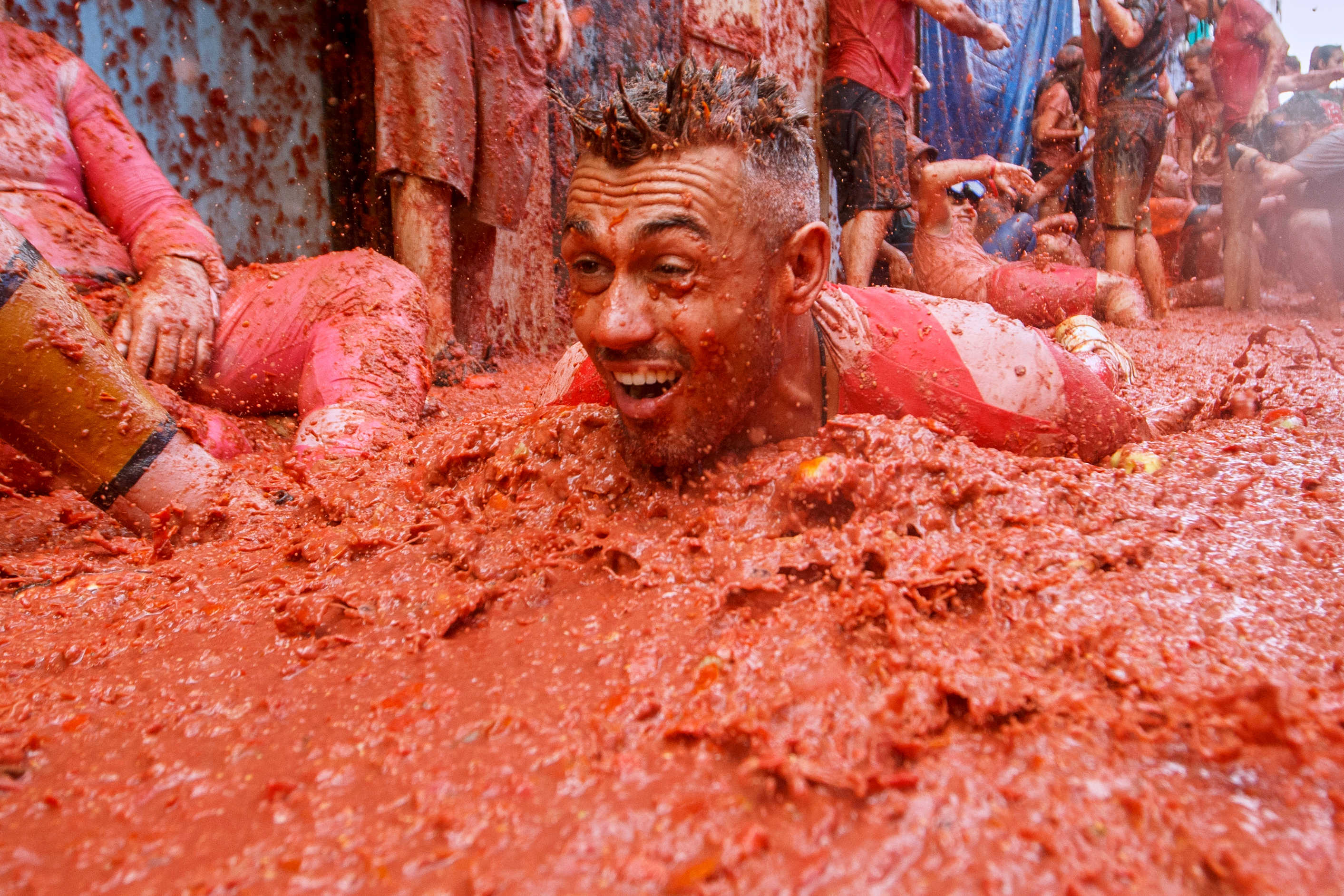 Un hombre se lanza sobre un charco de tomates durante la Tomatina, una fiesta anual de lucha de tomates, en el pueblo de Buñol, cerca de Valencia, España, el miércoles 27 de agosto de 2025. (Foto AP/Alberto Saiz)