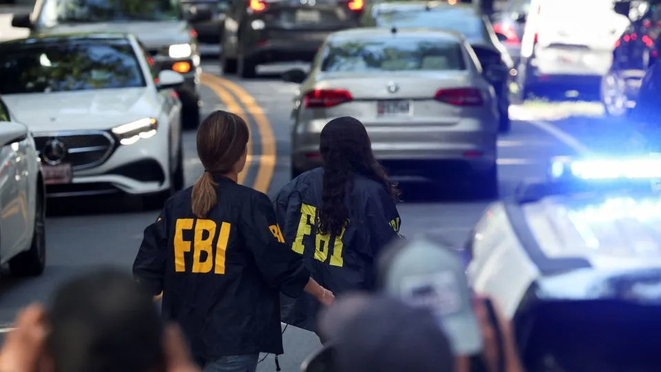 FBI members walk outside the home of the former Trump national security adviser John Bolton, in Bethesda, Maryland, on August 22. - Tasos Katopodis/Reuters