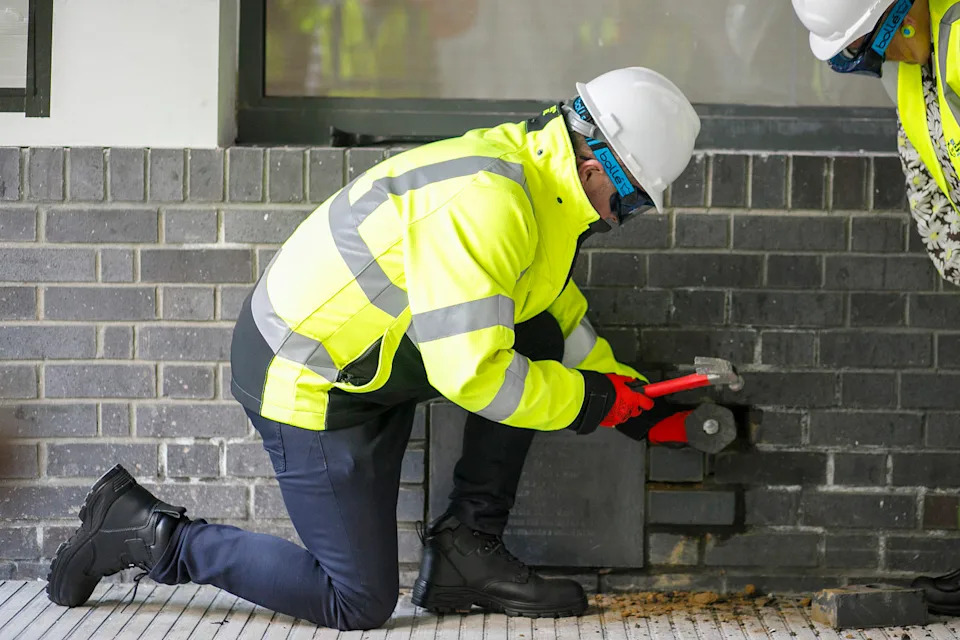 Jason Dawson from the Children's Cancer Centre chiseling the bricks around the time capsule. (Great Ormond Street Hospital for Children)