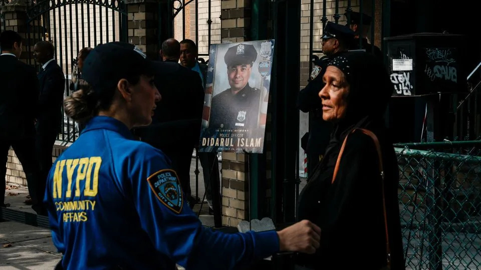 An NYPD employee speaks with a woman outside the funeral service. - Eduardo Munoz/Reuters