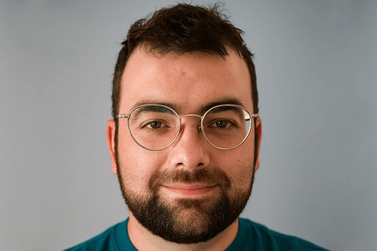 Elias, a bearded white man with round glasses, smiles.