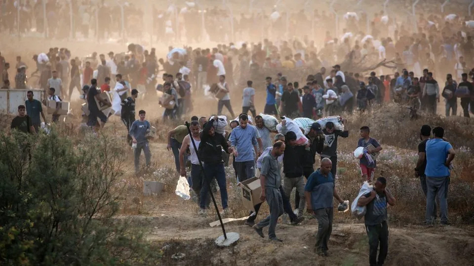 People carry relief supplies from the Gaza Humanitarian Foundation on June 7, 2025. - Eyad Baba/AFP/Getty Images