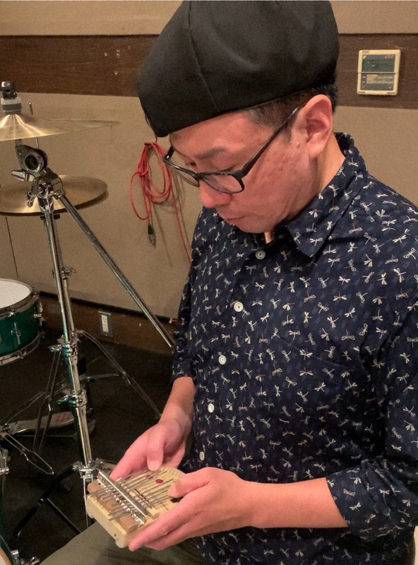 自作の「ゲームボーイカリンバ」を演奏する木佐貫洋平さん＝2025年7月21日午後2時5分、京都市内のスタジオで、前本麻有撮影