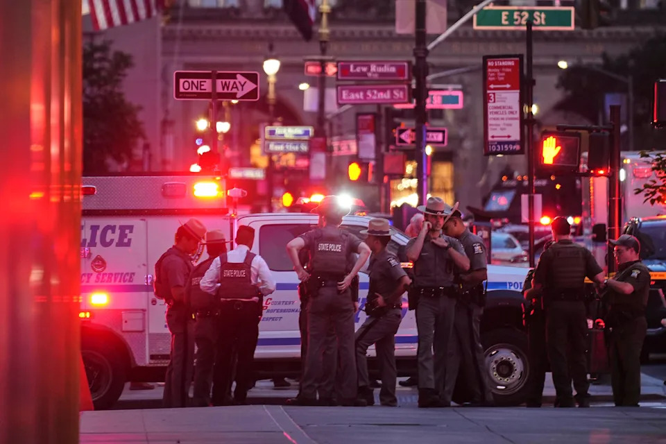 New York State Police troopers gather on 52nd Street outside a Manhattan office building where two people were shot, including a New York police officer, on July 28, 2025, in New York. / Credit: Angelina Katsanis / AP