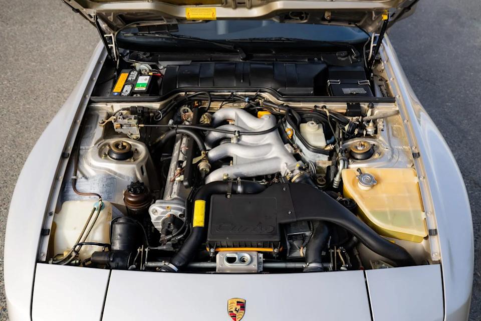 engine bay view showing intake manifold, hoses, and various engine components under open hood.