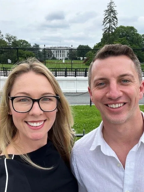 Denise Huskins and Aaron Quinn smiling in front of the White House