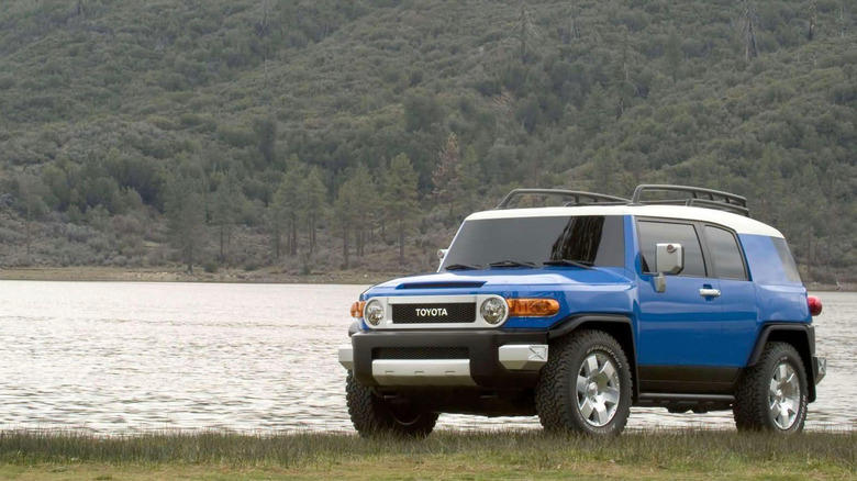 a honda element parked by a lake