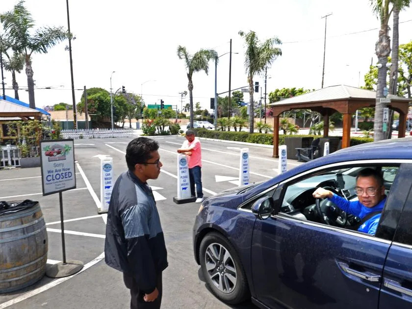 An employee of the Westchester Hand Wash tells a customer that they are closed