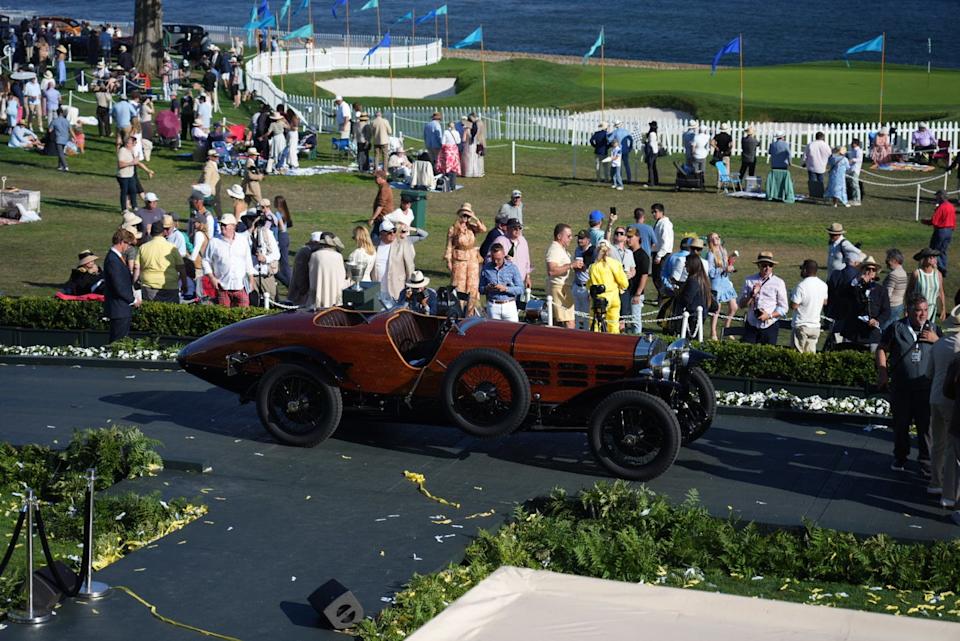 Vintage car showcased at an outdoor event with attendees