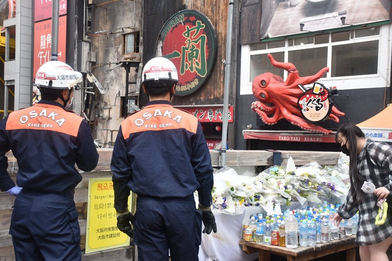 火災発生から1週間となった25日も多くの人たちが飲み物や花を手向けていた＝大阪市中央区で2025年8月25日午前10時18分、松原隼斗撮影
