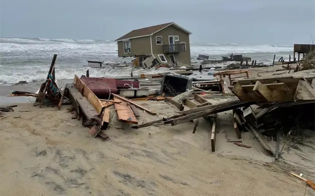 A portion of a collapsed house and associated debris in the ocean and on the beach at Rodanthe, North Carolina, on May 10, 2022. (NPS)