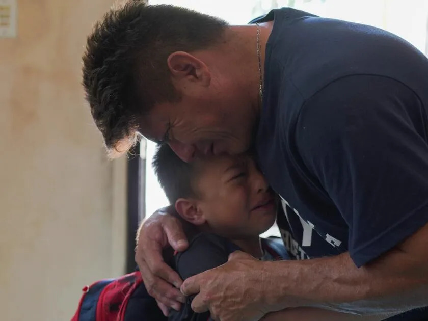 Jesus Cruz hugs his son Gabriel as they say goodbye