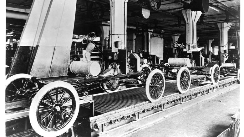 A line of Model T automobiles await further assembly. The Highland Park Ford Plant in Michigan is considered to be the birthplace of moving assembly lines.