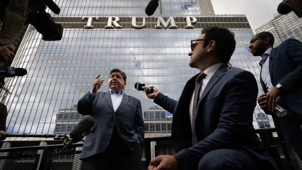 Illinois Gov. JB Pritzker speaks to the press while on board a water taxi passing Trump Tower on the Chicago River on Monday. - Scott Olson/Getty Images