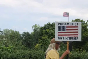  A protester holding a sign at Nebraska U.S. Rep Mike Flood’s town hall in Lincoln on Aug 4, 2025. (Juan Salinas II/Nebraska Examiner)