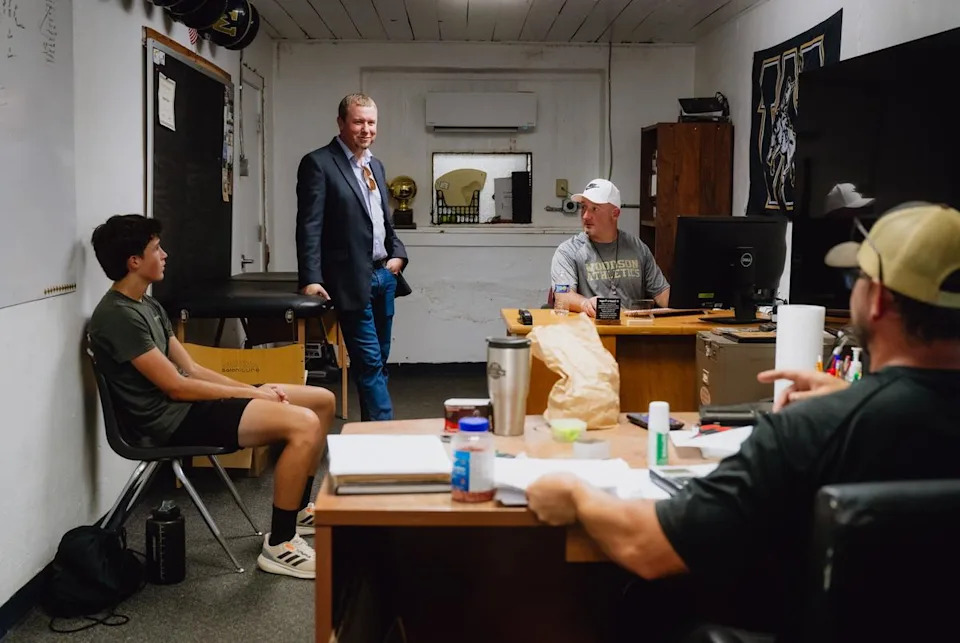 WOODSON, TEXAS — JULY 29, 2025: Casey Adams, superintendent of the Woodson Independent School District, second from left, speaks with Woodson boys’ athletic coaches at the Woodson ISD building in Woodson, Texas, on Tuesday, July 28, 2025. The district adopted a four-day school week model during the 2019–20 school year. CREDIT: Desiree Rios for The Texas Tribune