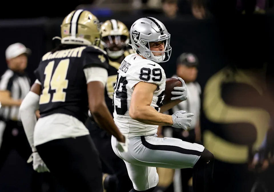 NEW  ORLEANS, LOUISIANA - DECEMBER 29: Brock Bowers #89 of the Las Vegas Raiders catches a pass as Kool-Aid McKinstry #14 of the New Orleans Saints defends during the first half of a game at the Caesars Superdome on December 29, 2024 in New Orleans, Louisiana.  (Photo by Derick E. Hingle/Getty Images)