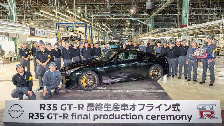 A Midnight Purple GT-R in the factory, surrounded by workers.