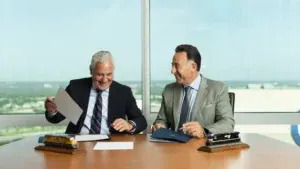 Union Pacific CEO Jim Vena, left, and Norfolk Southern CEO Mark George sign an agreement between the two companies that would create a true transcontinental railroad. (Courtesy of Union Pacific)