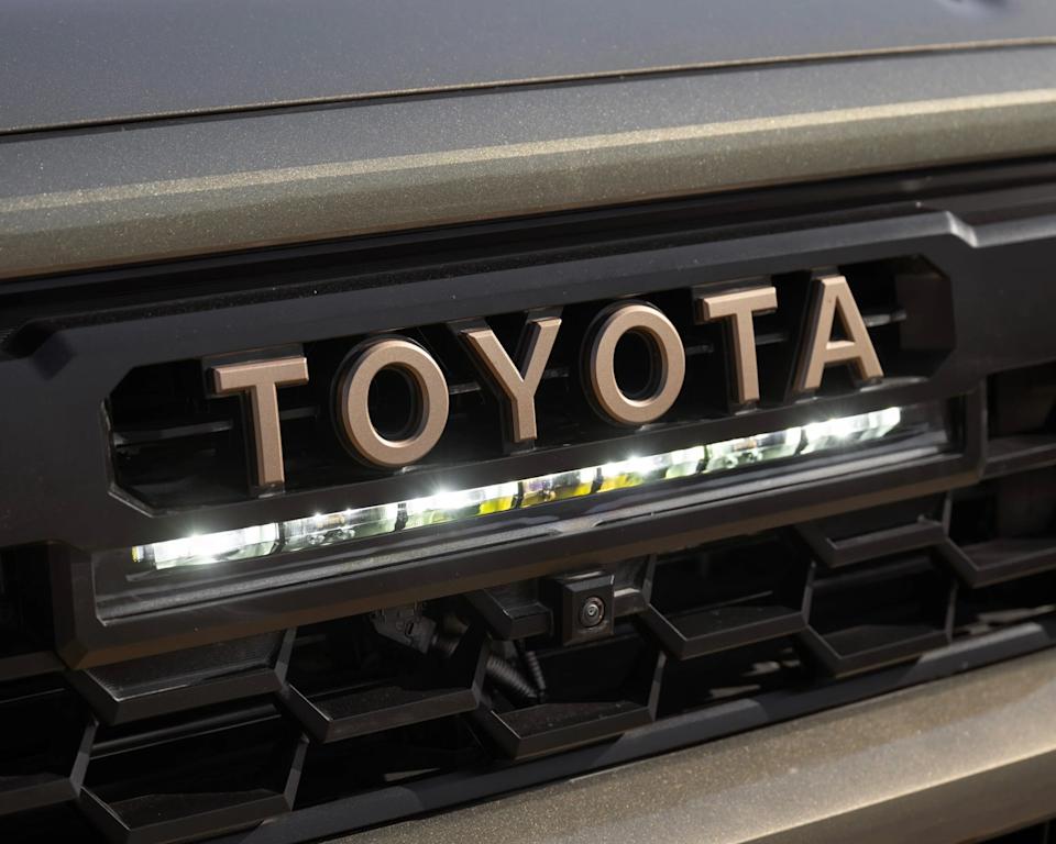 a close-up photo of a toyota grille badge with a lightbar underneath