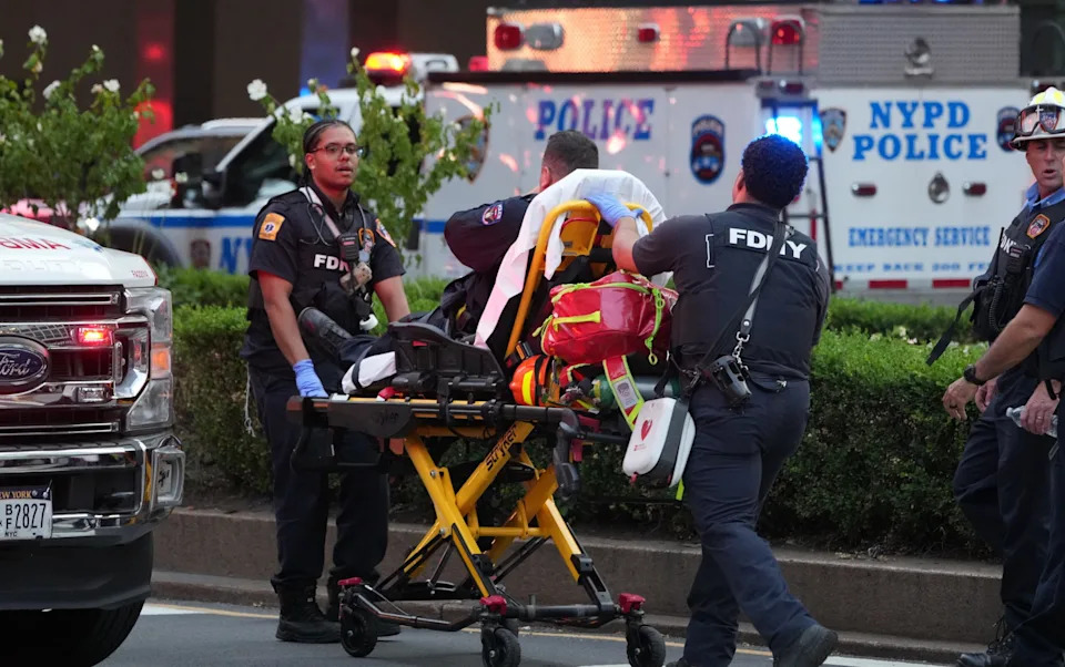 Emergency crews carry what appears to be an injured police officer from the scene