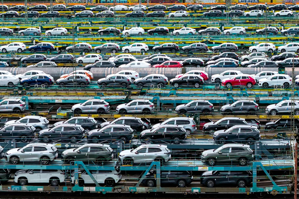 A view of many passenger cars parked on rail carrier cars.