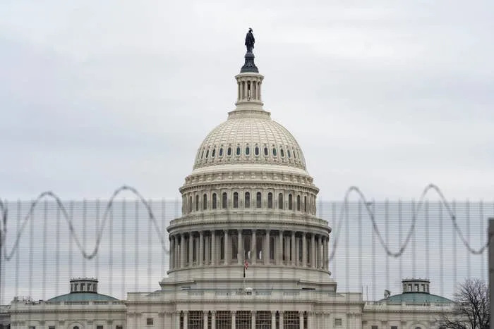 U.S. Capitol building with a fence in front, displaying a sense of security or restriction