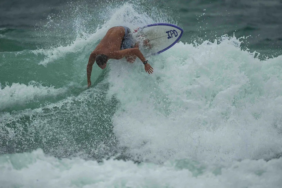A surfer carves into a wave just north of the William O. Lockhart Pier in Lake Worth Beach. The midday surf session was made possible by swells driven by Tropical Storm Helene in September 2024.