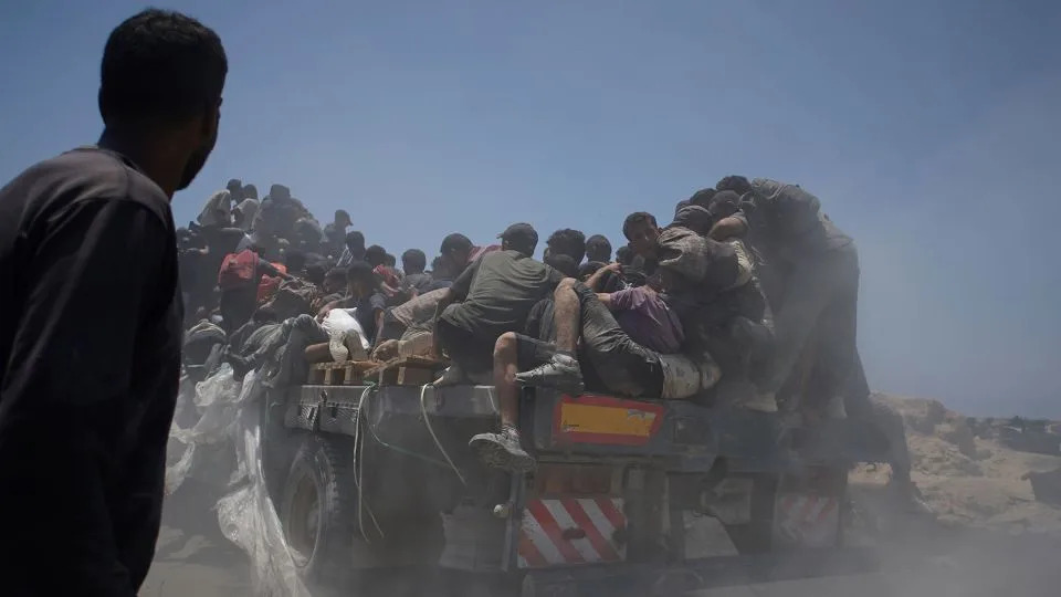 Palestinians hold onto an aid truck returning to Gaza City on July 22. - Jehad Alshrafi/AP/File