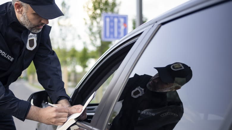 Cop performing a traffic stop on vehicle with tinted rear side windows