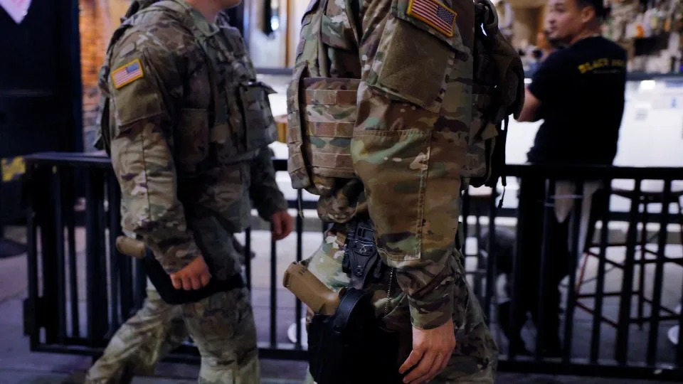 National Guard troops in Washington, DC, begin carrying weapons