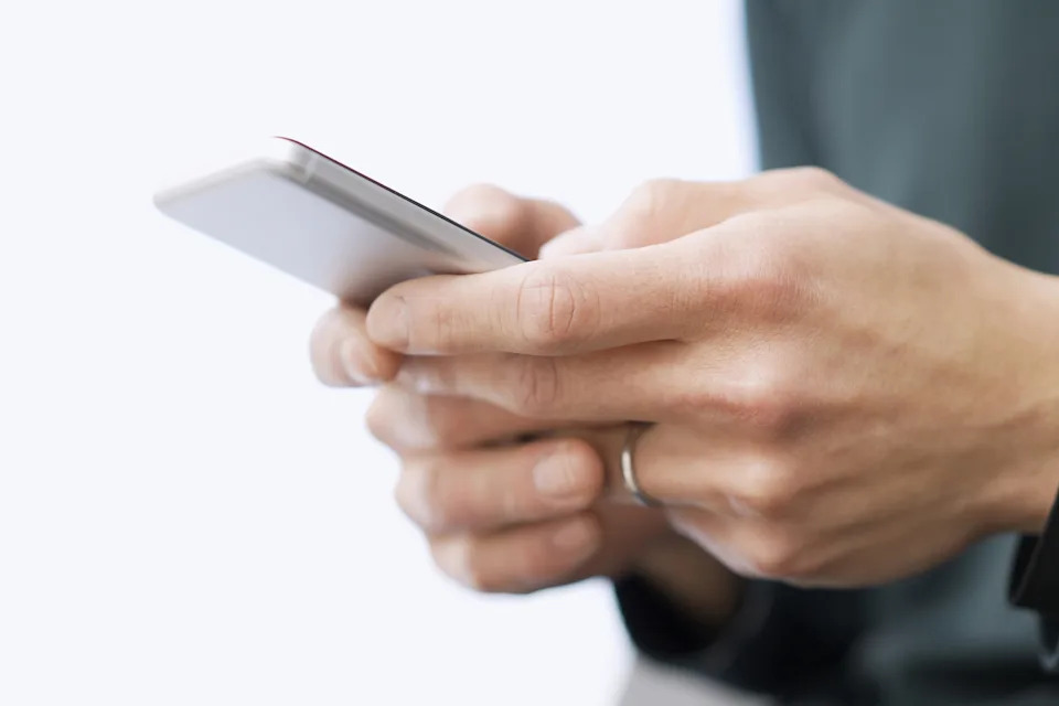 Person holding a smartphone, focusing on their hands and the device