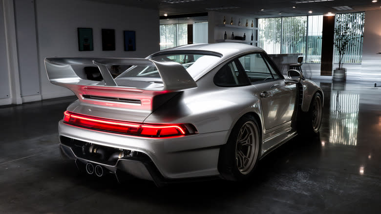 rear three-quarters view of the silver F-26 in a modern showroom space