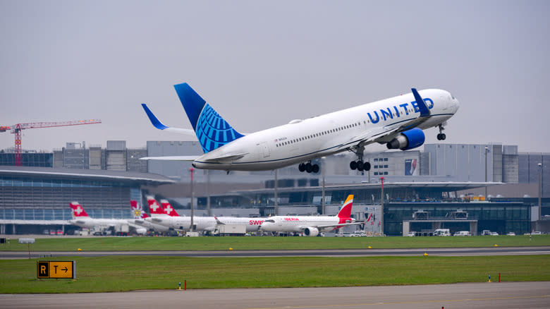 United Airlines airplane Boeing 767-322ER registration N652UA taking off from Zurich Airport on a foggy autumn day.