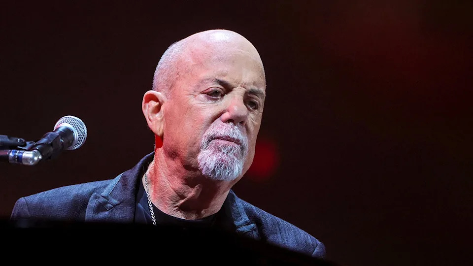 Billy Joel playing piano on stage