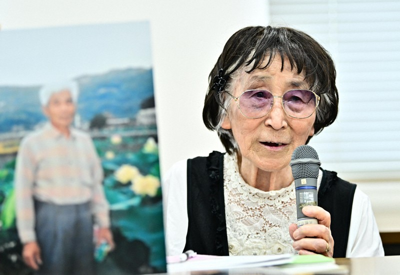 亡くなった松田忠徳さんの写真を掲げ、記者会見する被爆体験者訴訟原告団の岩永千代子さん。石破茂首相との面会時に松田さんの話をする予定でいたが、発言の機会が与えられなかった＝長崎市で2025年8月9日午後3時7分、北山夏帆撮影