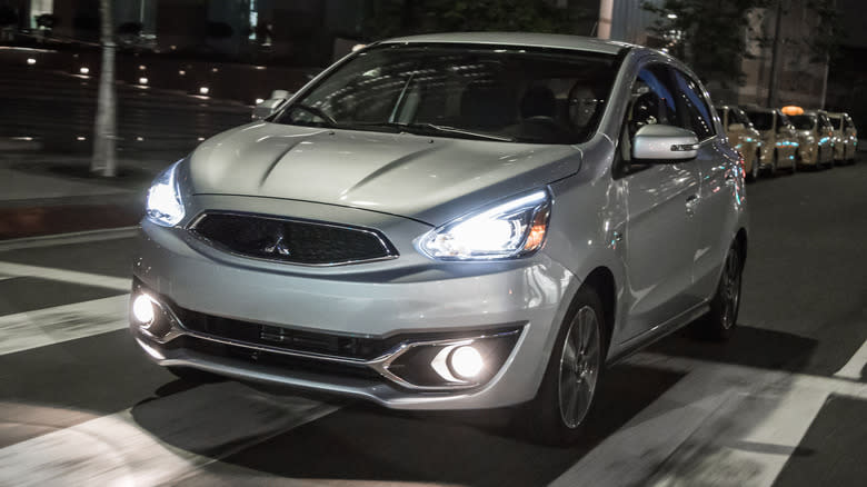 A silver 2018 Mitsubishi Mirage driving at night