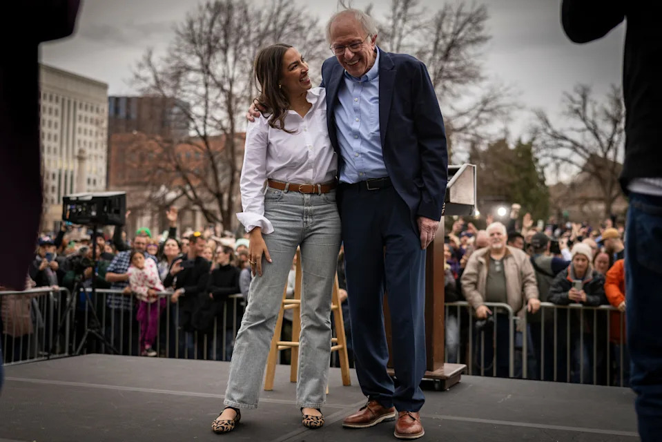 Rep. Alexandria Ocasio Cortez, D-NY, and Senator Bernie Sanders, I-VT, share a moment onstage during a rally on March 21, 2025 at Civic Center Park in Denver. Sanders And Ocasio-Cortez are holding a series of rallies they are calling the “Fight Oligachy" tour and will include stops in Tucson and Tempe, Arizona.